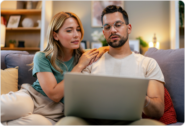 Young couple viewing laptop.